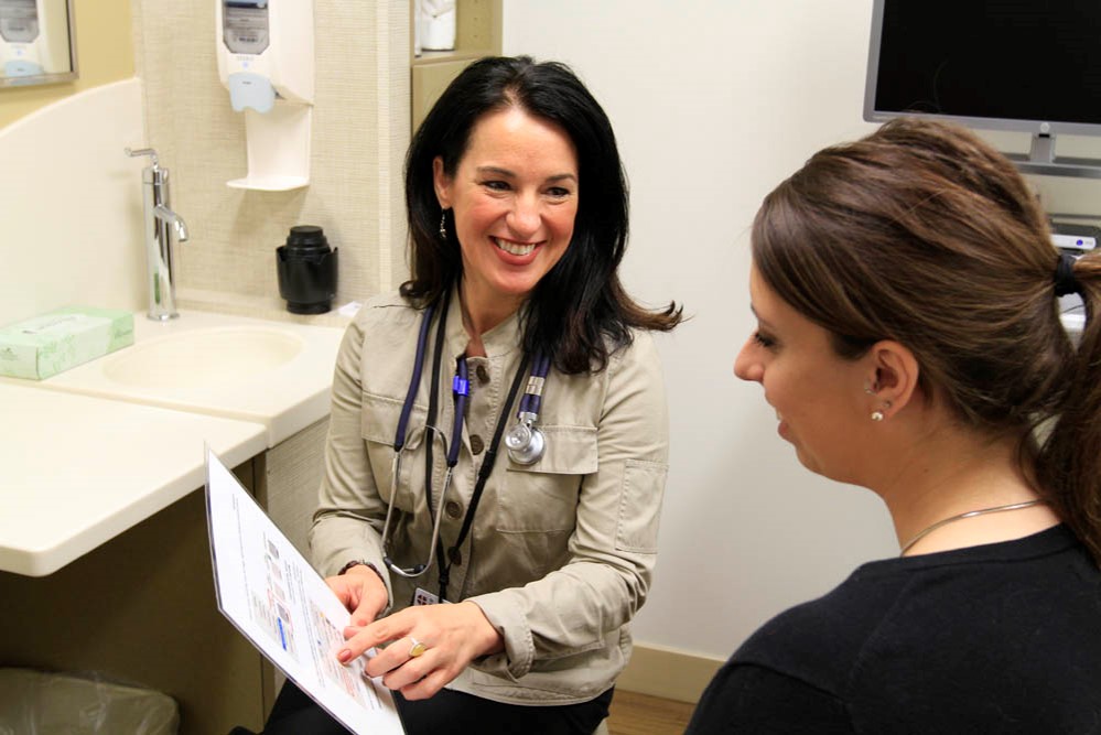 Patient Care Image of a physician speaking with a patient in an exam room