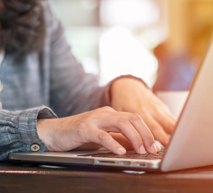 Photo of woman typing on laptop computer