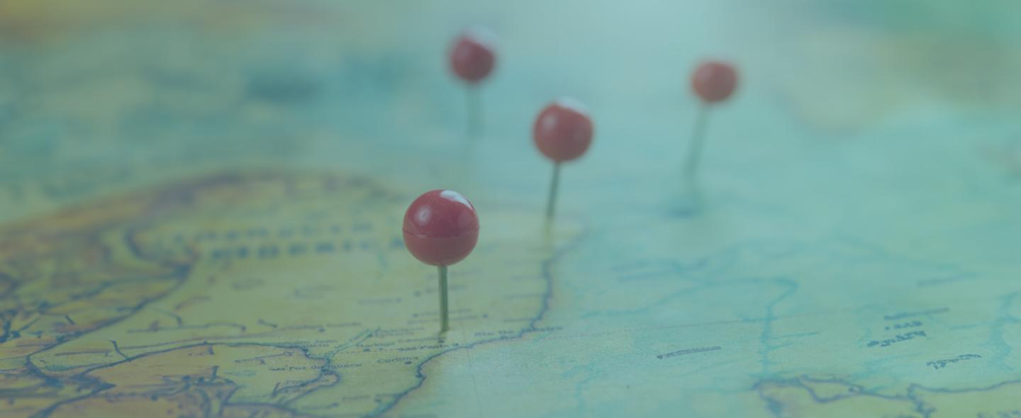 red push pins on an old map