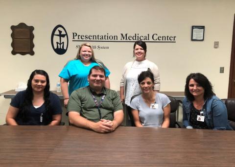 Pictured front row: Mandy Swain, Administrative Assistant, Chris Albertson, CEO, Lori Martinson, VP of Patient Services, Paula Wilkie, CFO; back row: Sarah Gailfus, Clinic Coordinator, Nikki Wilkes, Director of Care Coordination; not pictured: Wade Burges