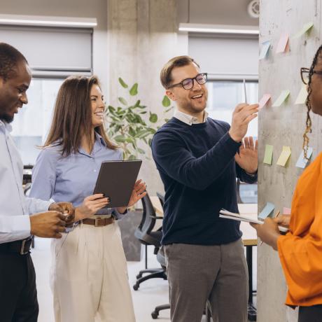 A group of four people discussing items on a display board 